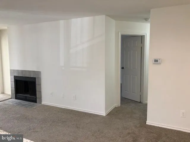 a view of an empty room with a fireplace and a window