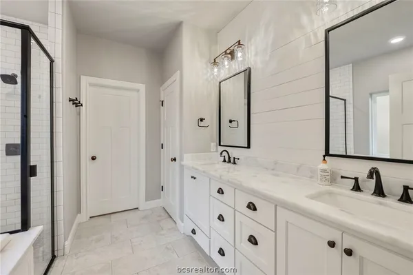 a bathroom with double sink and a mirror
