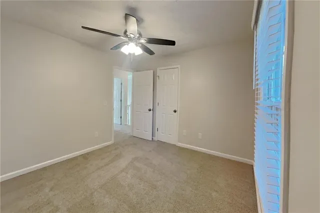 a view of an empty room with a chandelier fan
