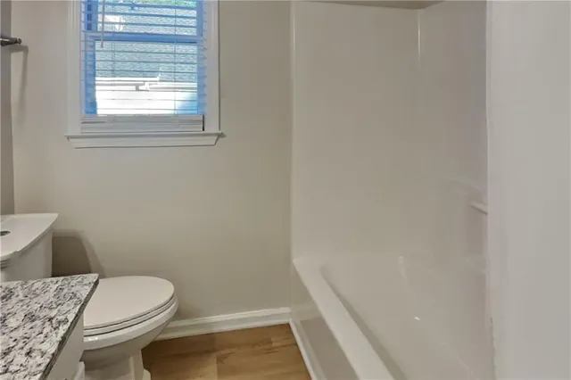 a white toilet sitting next to a window