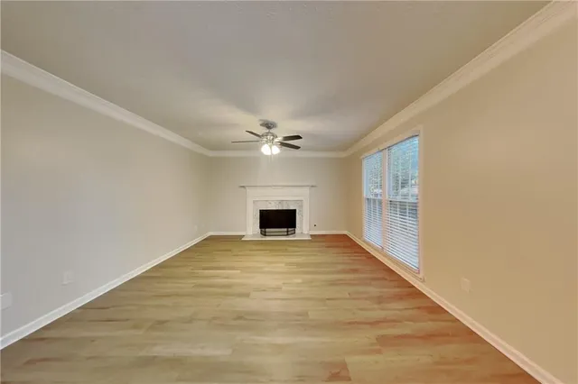 a view of an empty room with window and fireplace