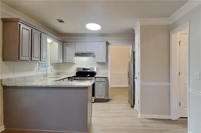 a kitchen with stainless steel appliances granite countertop a refrigerator a sink and a stove