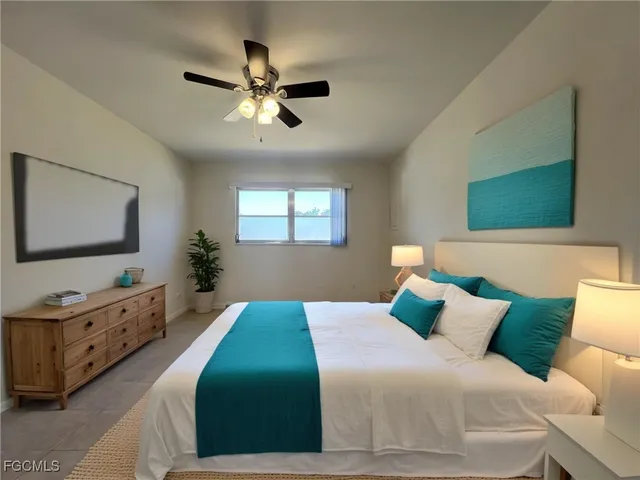 a bedroom with a bed and a chandelier fan