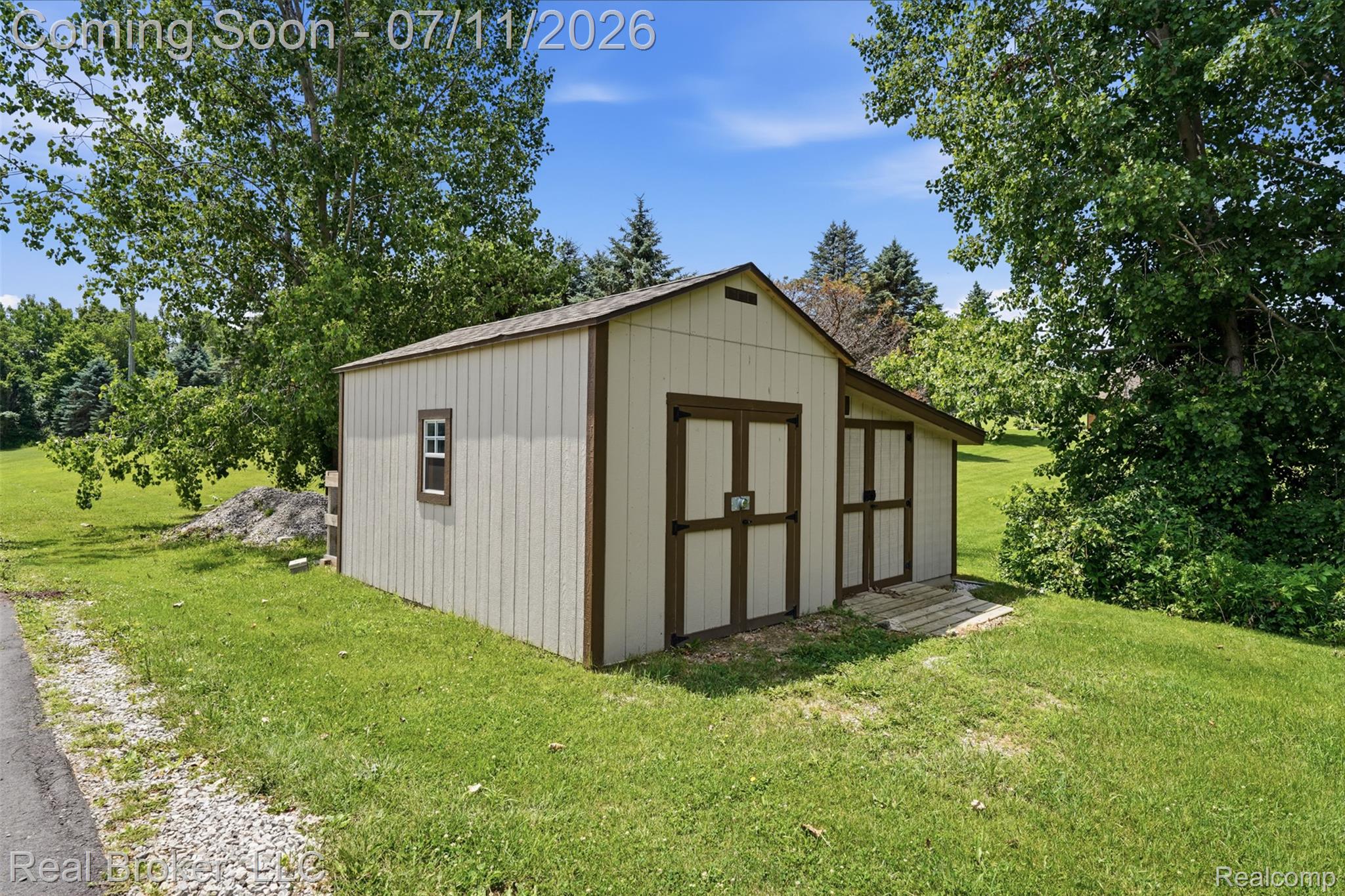 1050 West Brocker Road Metamora, MI 48455 - Photo 46 of 55 Gable-roofed outbuilding featuring vertical siding, a single pane window, and two sets of double barn doors