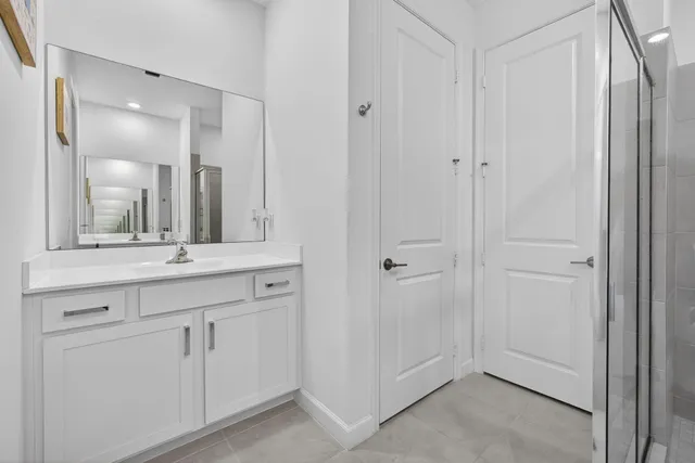 a bathroom with a shower sink and mirror