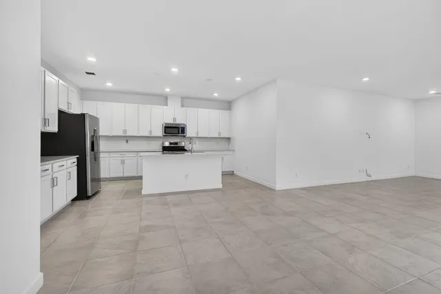 a kitchen with stainless steel appliances a refrigerator sink and microwave
