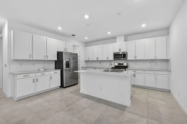 a kitchen with granite countertop white cabinets and stainless steel appliances