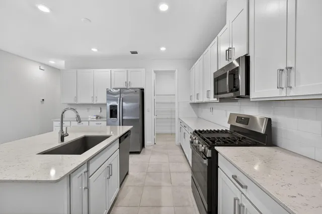 a kitchen with a sink stove top oven and refrigerator
