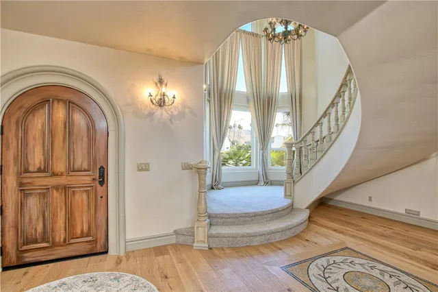 a view of a dining room with furniture a chandelier and wooden floor
