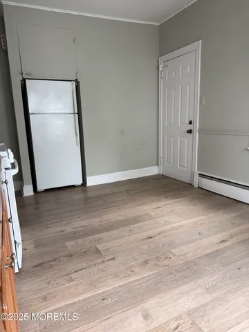 an empty room with wooden floor and mirror