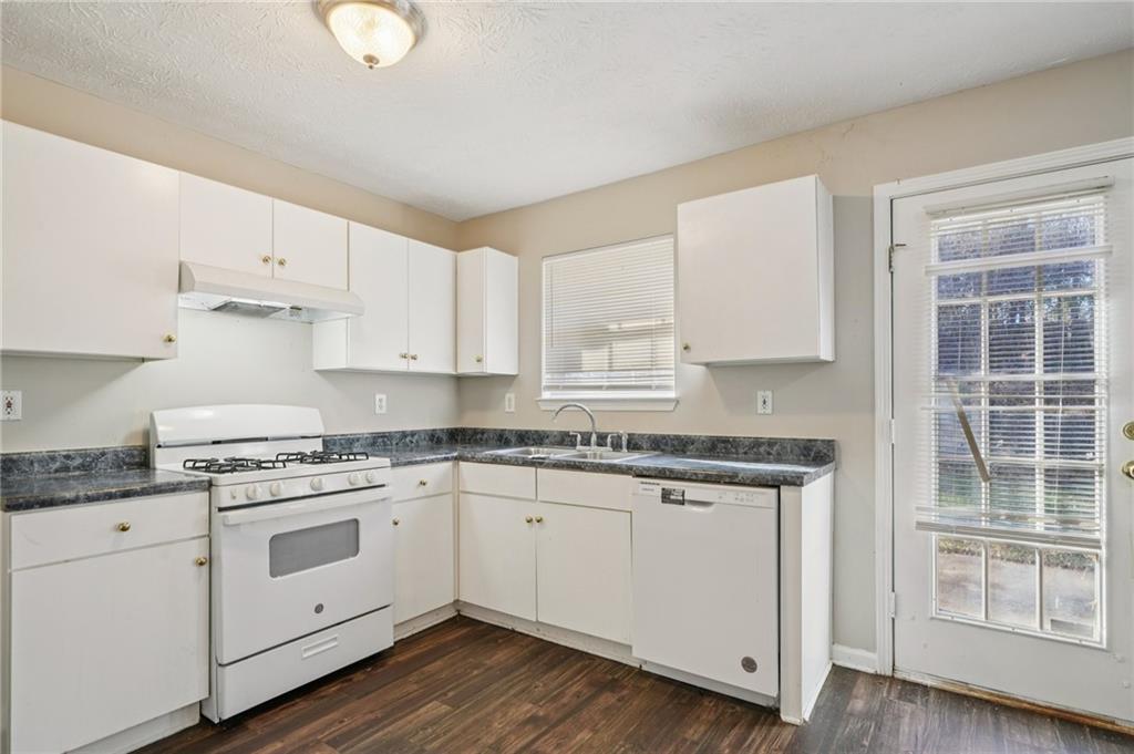 1443 Pebble Ridge Lane Hampton, GA 30228 - Photo 10 of 24 a kitchen with granite countertop white cabinets and white appliances