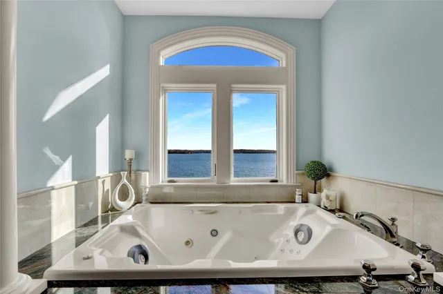 a bathroom with a tub and next to a window