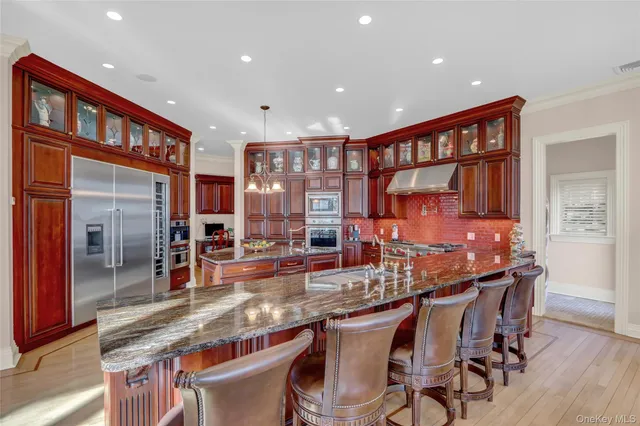 a dining hall with stainless steel appliances granite countertop a dining table and chairs