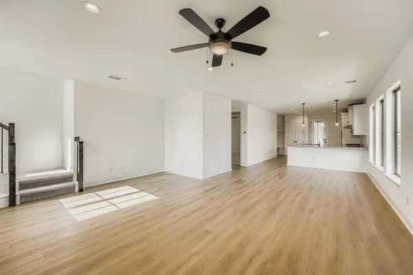 a view of a kitchen with wooden floor and a ceiling fan