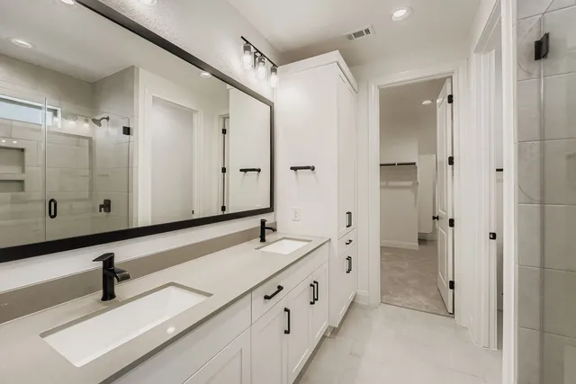 a bathroom with a double vanity sink and mirror