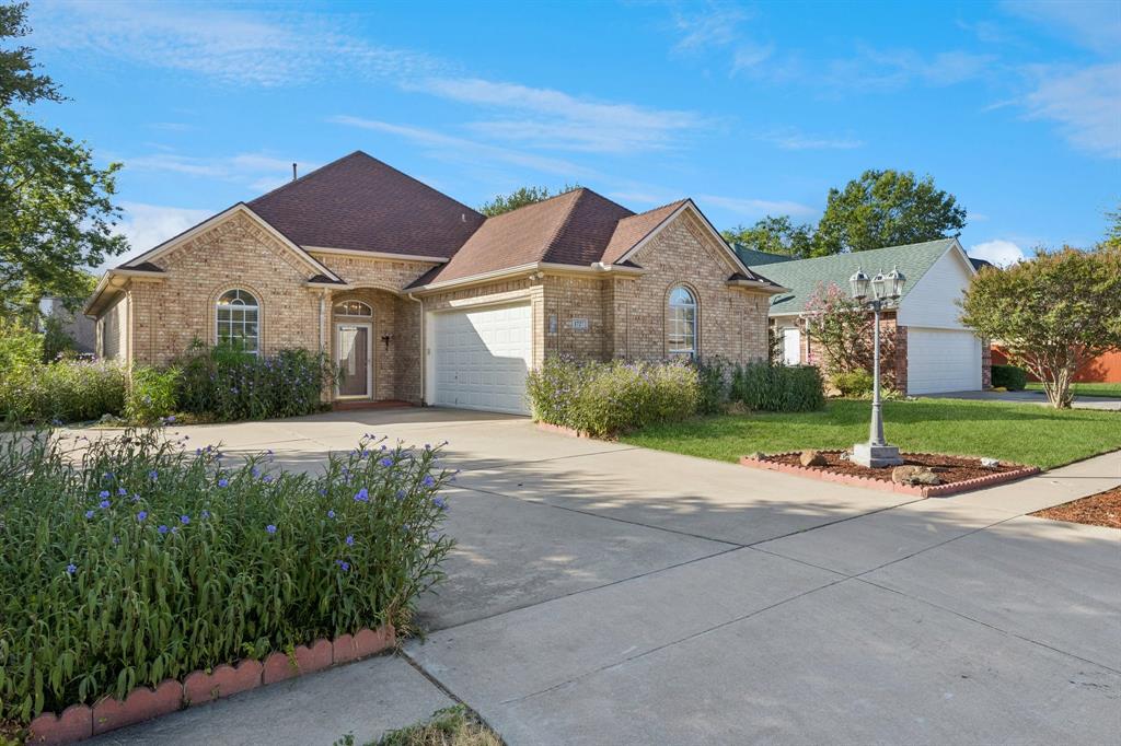 1727 Ridgecrest Drive Cleburne, TX 76033 - Photo 2 of 32 Brick exterior with arched windows, attached two-car garage, and a concrete driveway