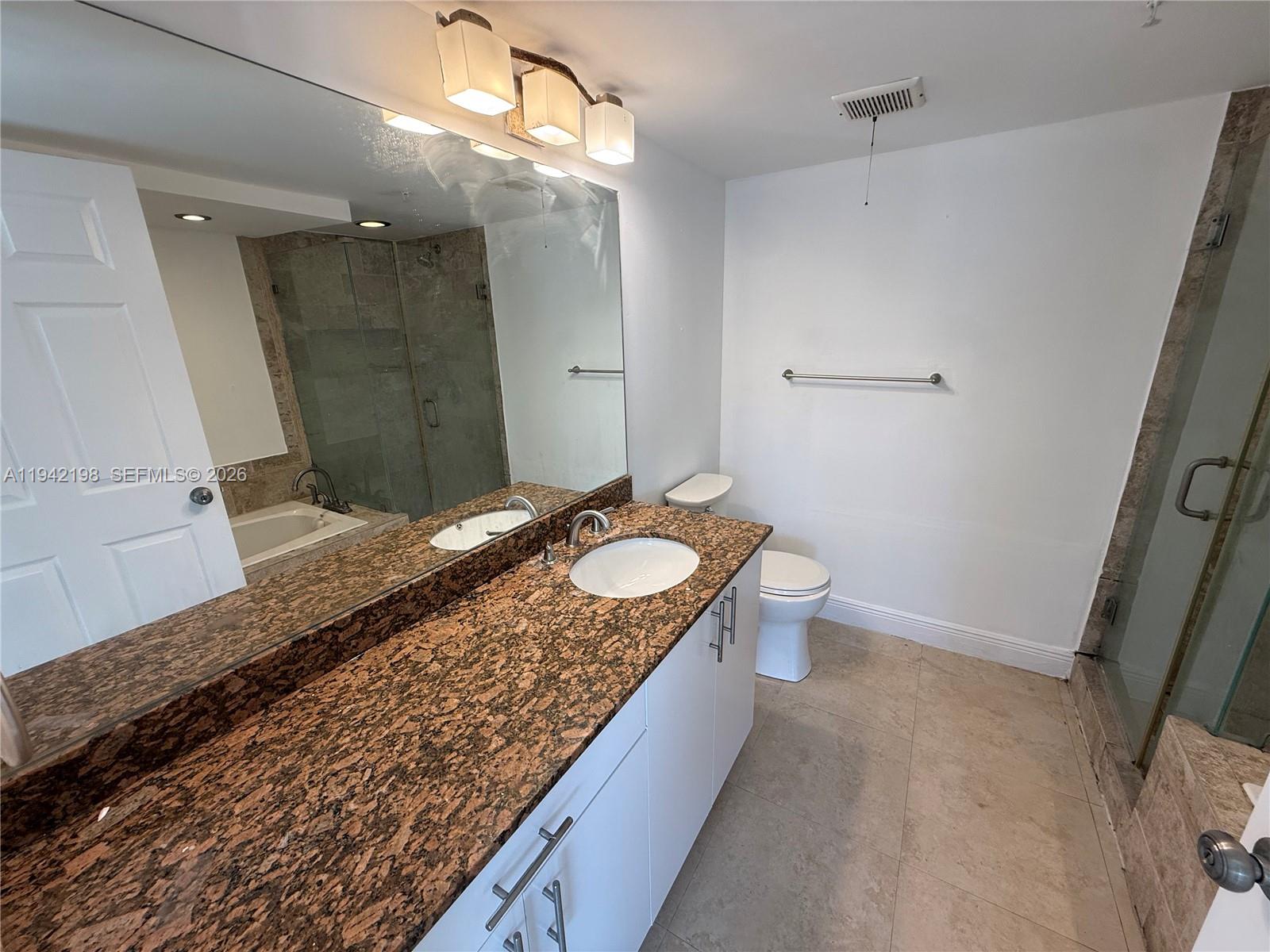 15460 Southwest 284th Street, Unit 4102 Homestead, FL 33033 - Photo 15 of 19 a bathroom with a granite countertop sink a toilet a mirror and shower
