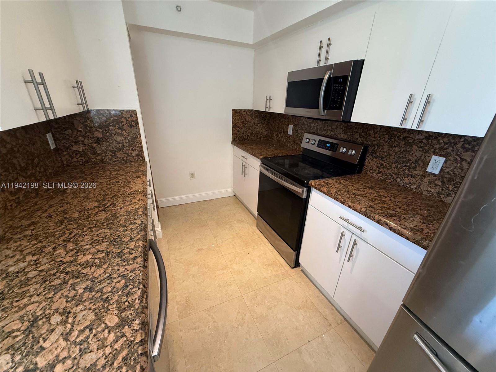 15460 Southwest 284th Street, Unit 4102 Homestead, FL 33033 - Photo 4 of 19 a kitchen with granite countertop a stove and a refrigerator