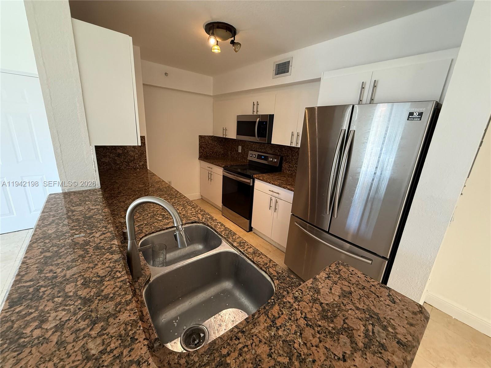 15460 Southwest 284th Street, Unit 4102 Homestead, FL 33033 - Photo 6 of 19 a kitchen with stainless steel appliances granite countertop a refrigerator and a stove