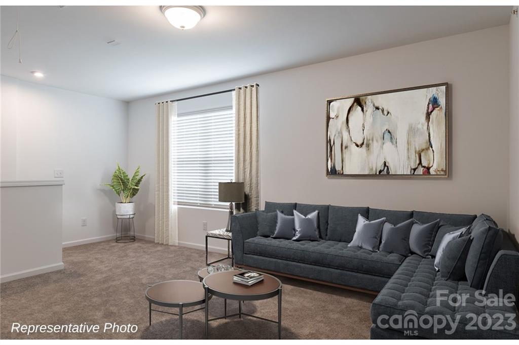 1244 Maple Shade Road Southwest, Unit 73 Concord, NC 28027 - Photo 7 of 12 a living room with furniture and a potted plant