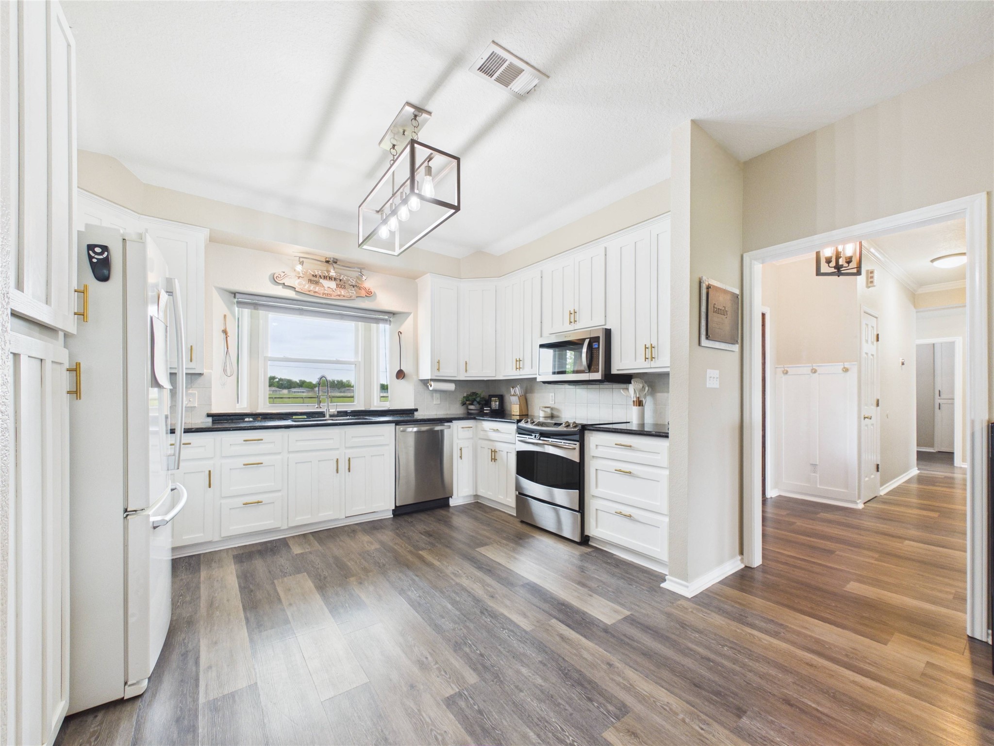 4610 Mustang Road Alvin, TX 77511 - Photo 15 of 50 Updated kitchen with a farm house sink, updated window overlooking the front yard, an updated light fixture and this room is open to the dining room with sight lines into the family room AND the sunroom/playroom!