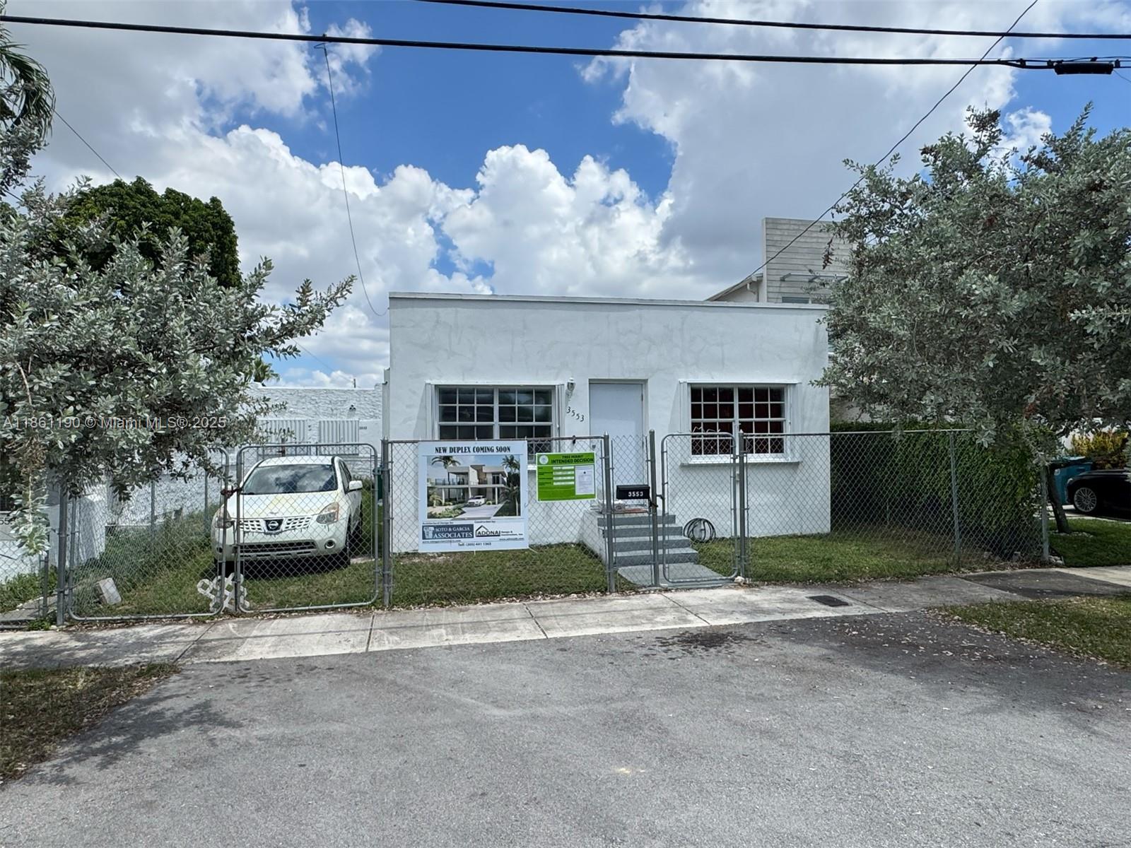 3553 Southwest 14th Street Miami, FL 33145 - Photo 10 of 12 a front view of a house with a yard and garage