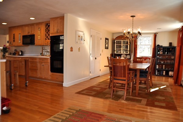 18 Riga Road Dover, MA 02030 - Photo 7 of 24 a kitchen with stainless steel appliances granite countertop a dining table chairs refrigerator and microwave