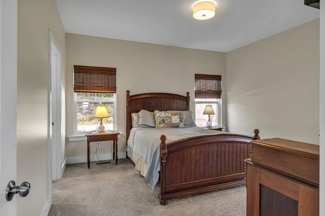 a bedroom with a bed and a lamp on dresser