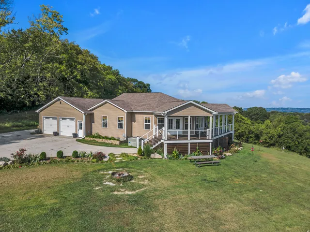 a view of a house with a big yard and large trees