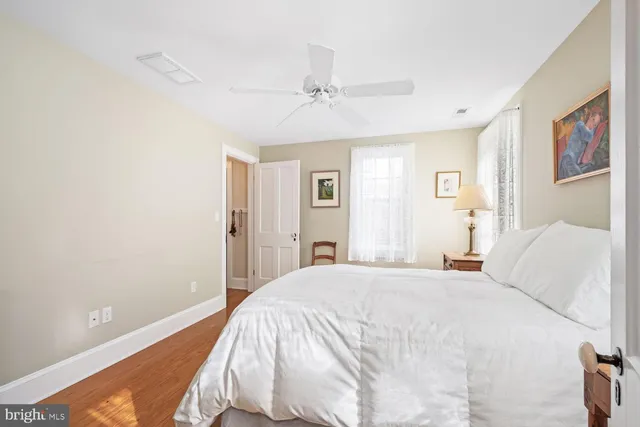 a view of a backyard with wooden fence and large trees