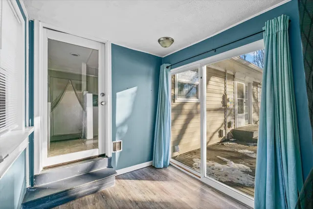 a view of a room with wooden floor and front door