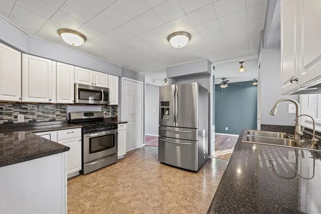 a kitchen with stainless steel appliances granite countertop a refrigerator stove and sink