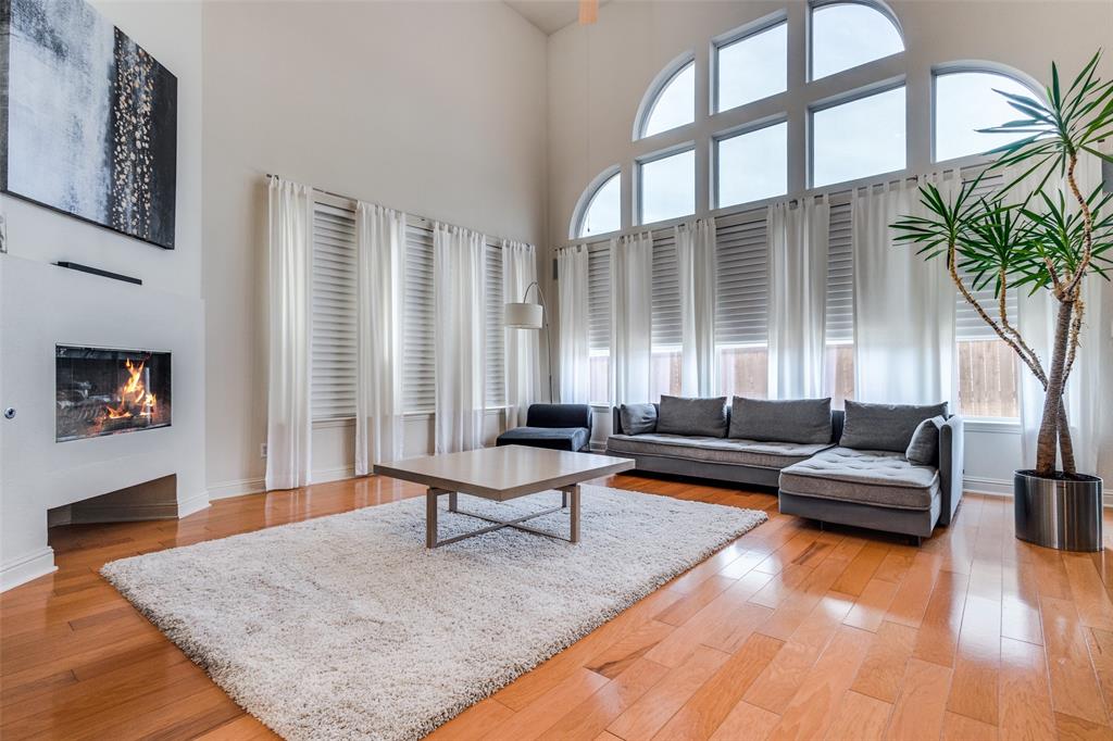 3313 Madison Avenue Hurst, TX 76054 - Photo 1 of 36 Living room with a towering ceiling and light wood flooring and modern fireplace.