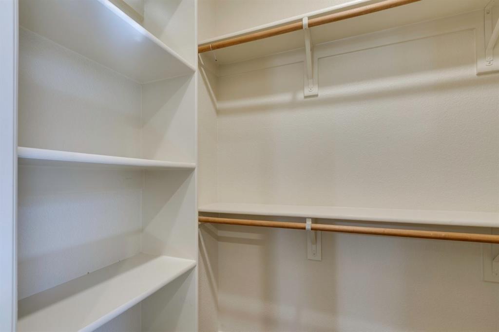 1522 Blue Jay Road Garland, TX 75043 - Photo 21 of 32 Walk-in closet featuring white built-in shelving and wooden hanging rods