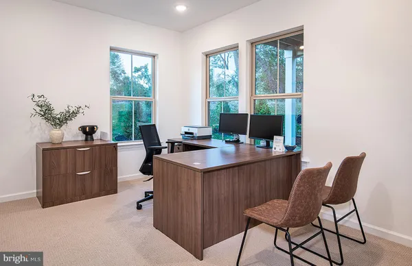 a view of a workspace with furniture and a window