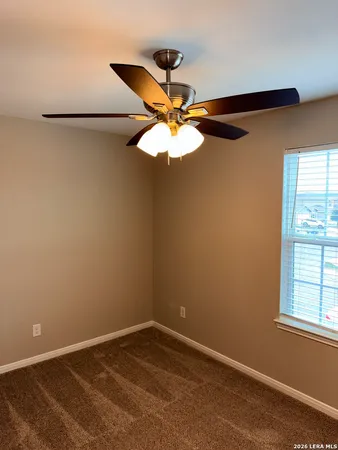 an empty room with a window and a ceiling fan