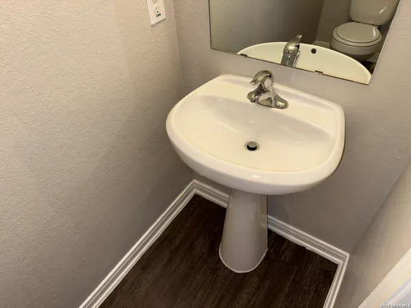 a bathroom with a sink toilet and a mirror