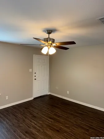 a view of wooden floor and a chandelier fan in a room