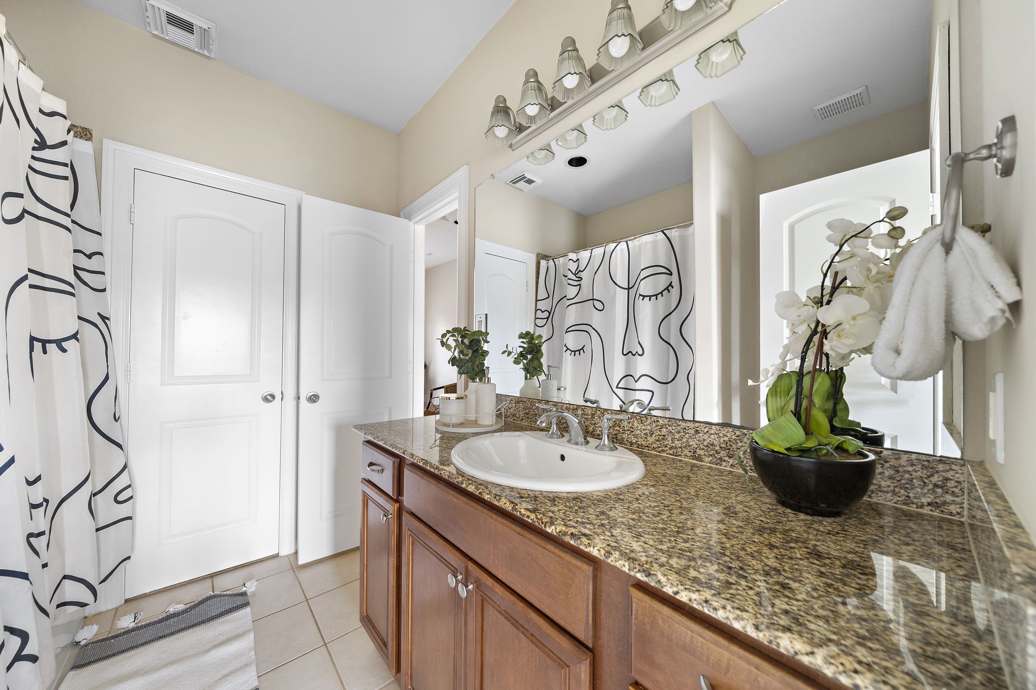 1913 Gillette Street, Unit C Houston, TX 77006 - Photo 17 of 23 a bathroom with a granite countertop sink a mirror and a shower curtain