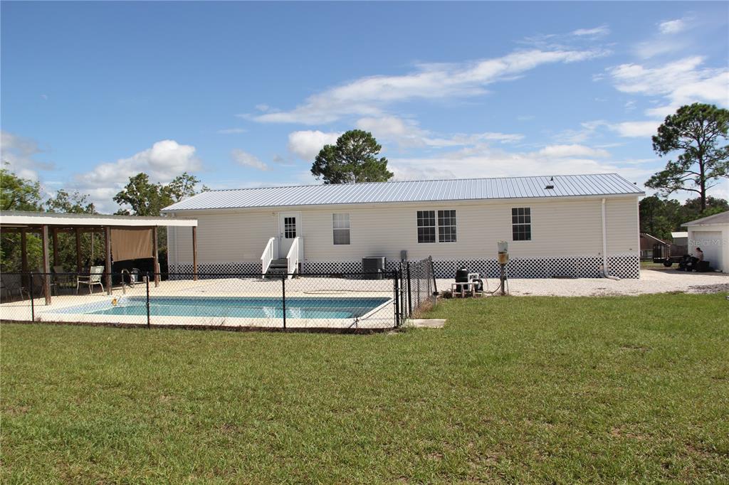 13127 Star Road Brooksville, FL 34613 - Photo 4 of 54 a view of a house with a backyard porch and sitting area