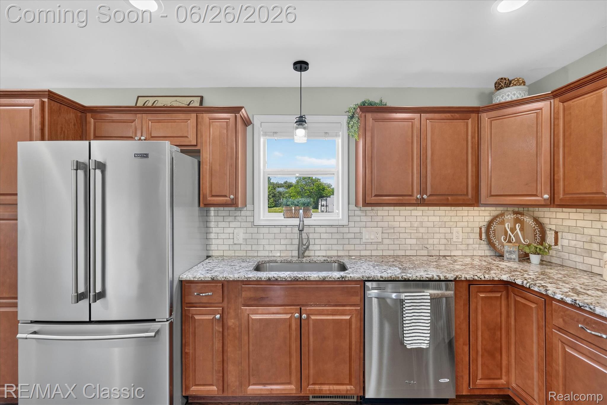 3205 North Milford Road Highland, MI 48357 - Photo 15 of 53 Kitchen featuring wood cabinetry, light-colored granite countertops, and a subway tile backsplash