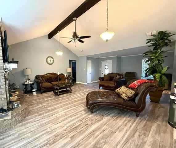 a living room with furniture a window and a flat screen tv