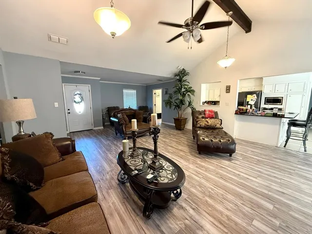 a living room with furniture and a wooden floor