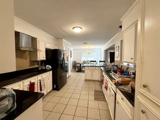 a large white kitchen with a stove a sink dishwasher and a microwave oven