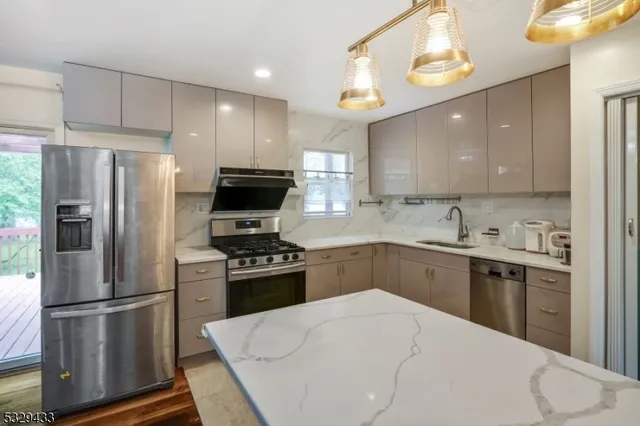 a kitchen with stainless steel appliances a refrigerator stove microwave and sink