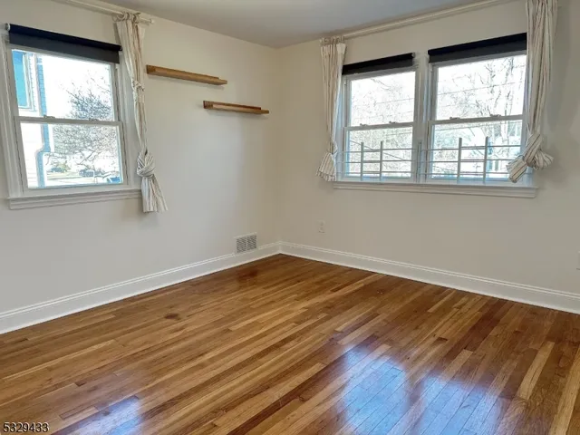 a view of a room with wooden floor and windows