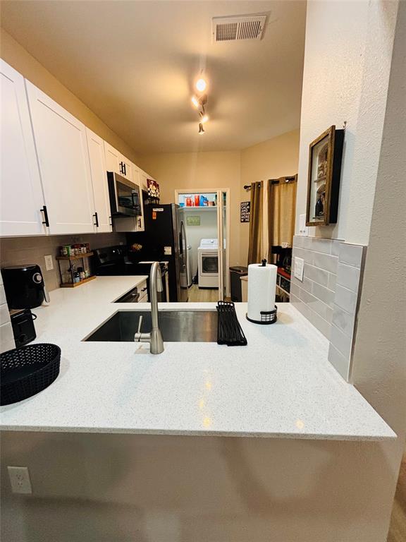 14277 Preston Road, Unit 416 Dallas, TX 75254 - Photo 35 of 40 White upper and lower cabinetry, stainless steel undermount sink, gooseneck faucet, light-toned countertop, and light gray subway tile backsplash