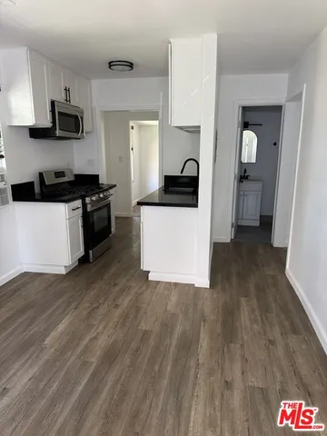 a kitchen with stainless steel appliances a sink a stove top oven a counter space and cabinets