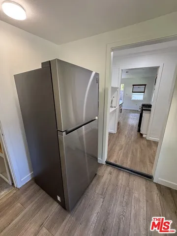 a kitchen with a refrigerator and wooden floor
