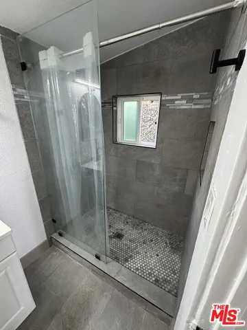 a bathroom with a shower and a sink